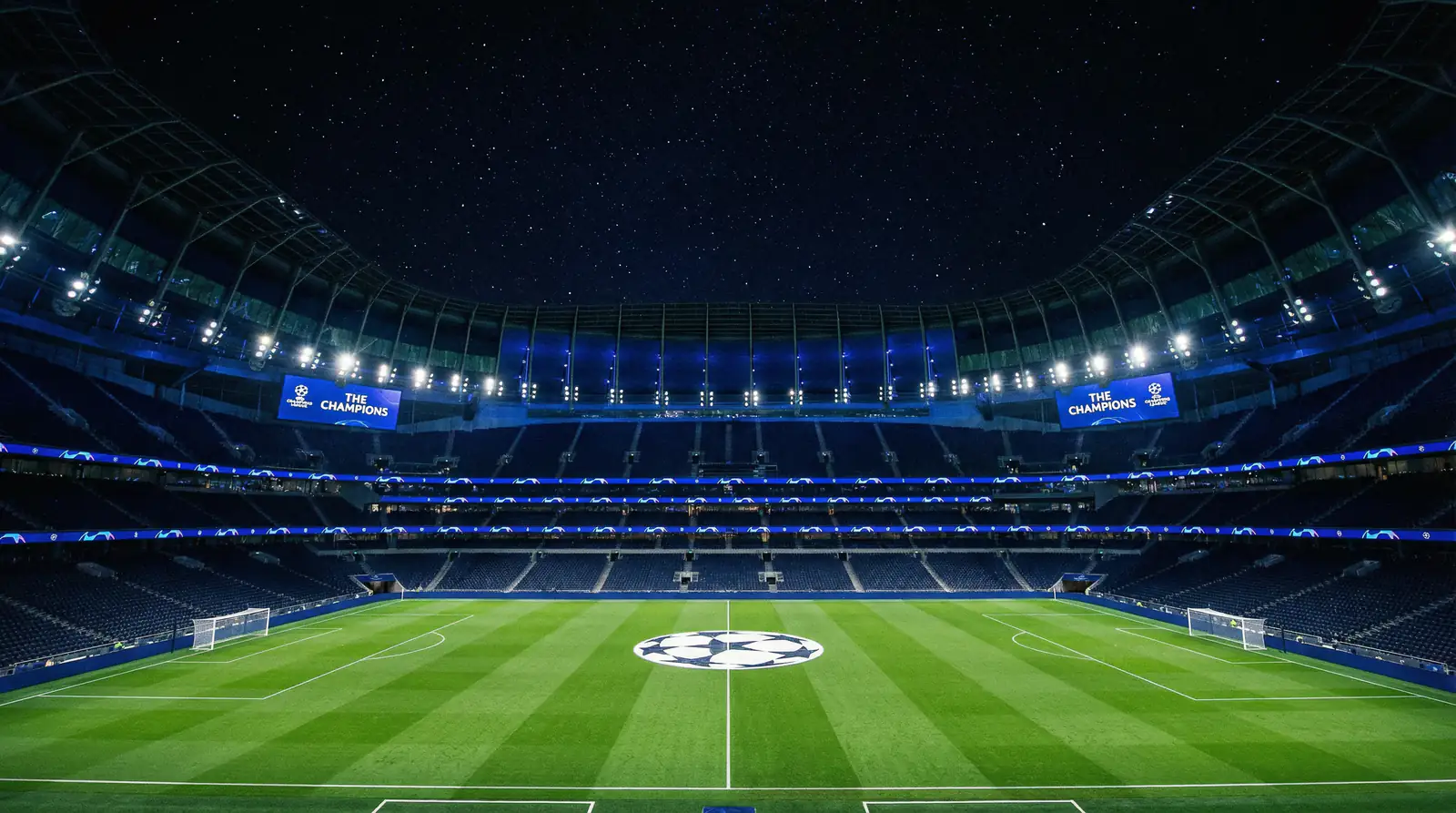 Stadio di Champions League illuminato di notte con il campo da calcio in primo piano